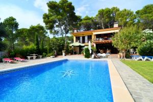 una casa con piscina frente a una casa en Los Pinos, en L'Estartit