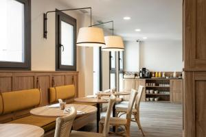 un restaurant avec des tables et des chaises en bois ainsi qu'un miroir dans l'établissement Petit Palace Vargas, à Séville