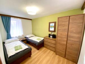 sypialnia z 2 łóżkami i komodą w obiekcie Chalet 3 Domky 182 w Demianowskiej Dolinie