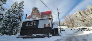 a building is covered in snow on a street at ロッジＴＯＮＢＯ・石打 in Minami Uonuma