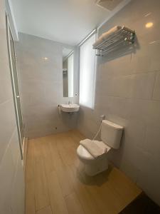 een badkamer met een toilet en een wastafel bij Swasana Hotel Medan in Medan