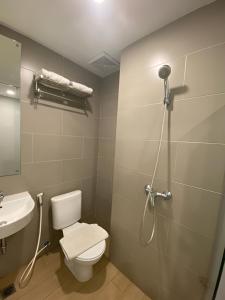 a bathroom with a shower and a toilet and a sink at Swasana Hotel Medan in Medan