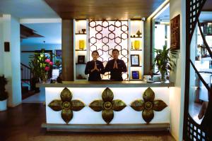 eine Vitrine in einem Laden mit zwei Personen in der Unterkunft Siem Reap Palace Hotel & Spa in Siem Reap