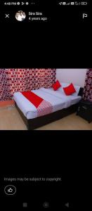 a picture of a bed with red pillows on it at Murugan residency in Thekkady