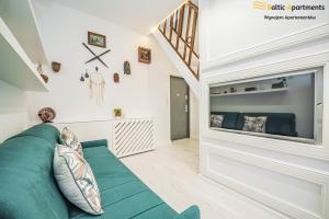 ein Wohnzimmer mit einem grünen Sofa und einem großen TV in der Unterkunft Baltic Apartments - Willa Carmen DeLuxe in Świnoujście