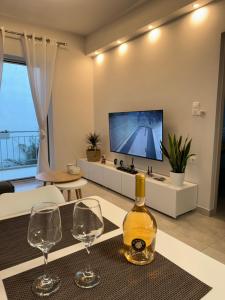 een woonkamer met twee wijnglazen en een tv bij Your ideal stay in Athene