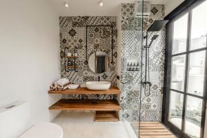 een badkamer met een wastafel en een spiegel bij Sarang Apartments by EVDEkimi Ubud in Ubud