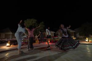 a group of people dancing in the street at night at Prince Desert Camp in Sām +164 photos