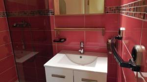a red bathroom with a sink and a mirror at Duplex station alpe du grand serre in La Morte