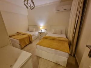 艾因苏赫纳شاليه لاجونا باي السخنه Chalet at laguna bay Sokhna的小型客房配有2张床和水槽。 更多37张照片