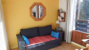 a living room with a couch and a mirror at Duplex station alpe du grand serre in La Morte