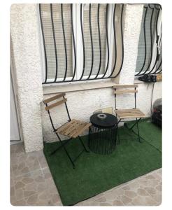 2 chaises et une table en face d'un bâtiment dans l'établissement Studio avec extérieur climatisée, à Marseille