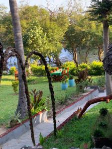 un parque con palmeras, mesa y sillas en Mafia Beach Bungalows sea view, en Utende