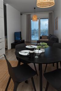 a living room with a black table and chairs at Holiday Apartment Aava 1 in Rovaniemi