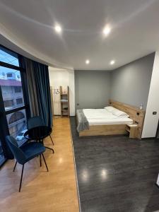 een slaapkamer met een bed, een tafel en een stoel bij ABC HOTEL in Jerevan