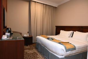 a hotel room with a bed and a desk at Emaar Al Manar in Makkah