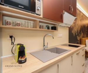 a kitchen counter with a sink and a microwave at Grand Suites Central in Budapest