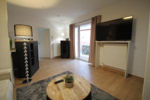 a living room with a table and a flat screen tv at Apartment im Zentrum von Bad Schwartau in Bad Schwartau