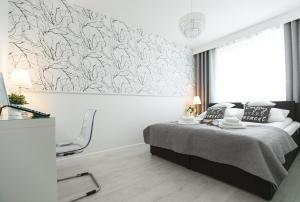 een slaapkamer met een bed en een schilderij aan de muur bij Silver Apart Rzeszów in Rzeszów