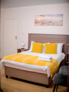 um quarto com uma cama grande e almofadas amarelas em Entire 1 Bed, 5 mins 2 Game City, free Netflix & showmax em Gaborone