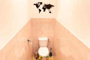 a bathroom with a toilet with a map on the wall at Le Lodge Safari au centre-ville in Cayenne