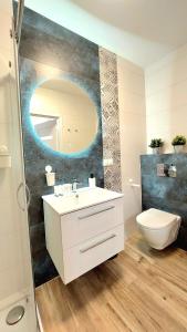 a bathroom with a sink and a toilet and a mirror at Apartament Perła Jantaru by TriApart in Jantar