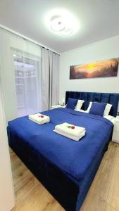 a blue bed with two towels on top of it at Apartament Perła Jantaru by TriApart in Jantar