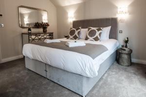 1 dormitorio con 1 cama grande y espejo grande en Bramley Brook Cottage 5* Luxury, en Whalley