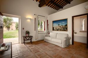 a living room with a white couch and a window at Tenuta Pianirossi in Cinigiano
