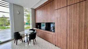 uma sala de jantar com uma mesa e uma parede com uma televisão em West Vista Apartment JKT Modern Design w/55” TV and 40/mbps Wi-fi em Jakarta