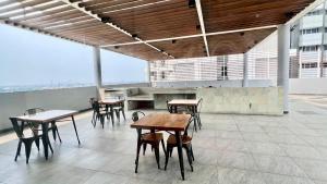 uma sala com mesas e cadeiras num edifício em West Vista Apartment JKT Modern Design w/55” TV and 40/mbps Wi-fi em Jakarta
