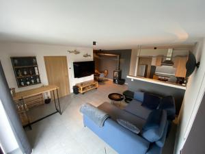 uma sala de estar com um sofá azul e uma televisão em Stilvolles Apartment - mit E-Auto Lademöglichkeit em Attendorn