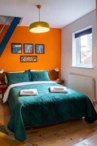 een slaapkamer met een groen bed en een oranje muur bij 1960s Inspired City Centre Apartment for 4 with Parking in Norwich