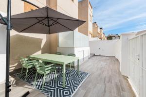 une terrasse avec une table et des chaises vertes ainsi qu'un parasol dans l'établissement Sunrise Bulnes Golf 1, à Ciudad Quesada