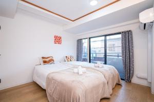 1 dormitorio con 2 camas y ventana grande en Aurora 3, en Tokio