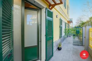 una porta di un edificio con persiane verdi di Helios a La Spezia