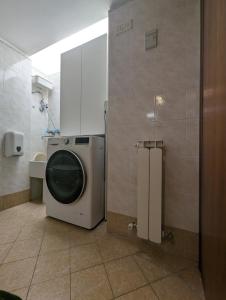 ein Badezimmer mit einer Waschmaschine und einem Waschbecken in der Unterkunft Monteforte Home - Ruggero in Catania