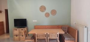appartamento aroma في Radicondoli: غرفة طعام مع طاولة وتلفزيون