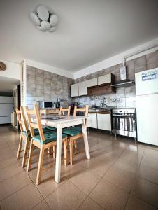 eine Küche mit einem Tisch und Stühlen sowie einem Kühlschrank in der Unterkunft Monteforte Home - Ruggero in Catania