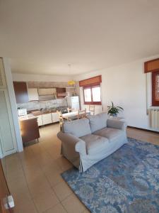 ein Wohnzimmer mit einem Sofa und einer Küche in der Unterkunft Monteforte Home - Ruggero in Catania