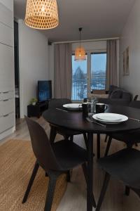 a dining table and chairs in a living room at Holiday Apartment Aava 3 in Rovaniemi