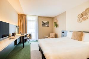 Habitación de hotel con cama y escritorio en Green Park Hotel Brugge en Bruges