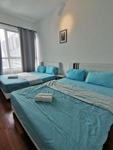 3 Betten in einem Zimmer mit blauen Kissen in der Unterkunft Stay in I-City I-SOHO in Shah Alam