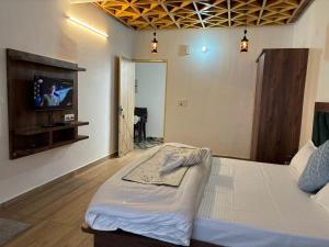 a bedroom with a bed with a tv on the wall at Mid Hills Home Stay in Kasauli