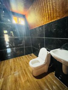łazienka z toaletą i umywalką w obiekcie Wild Brooke Hut w mieście Vythiri