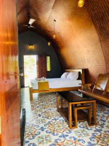 a bedroom with a bed and a table in a room at Wild Brooke Hut in Vythiri