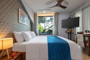 a hotel room with a bed and a tv at Oriana Hotel & Apartment in Hanoi