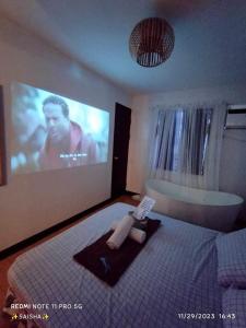 a bedroom with a person laying on a bed in front of a tv at La Caša Dulce Staycation Main Account in Imus