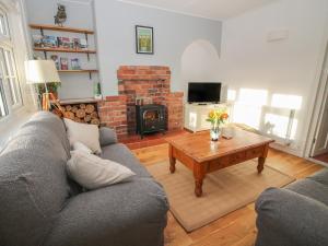 a living room with a couch and a table with a fireplace at 8 New Houses in Wrexham