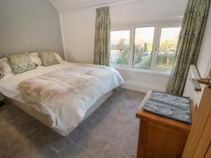 a bedroom with a bed and two windows at 8 New Houses in Wrexham